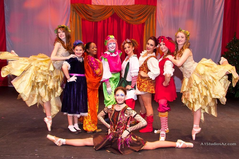 A group of young girls are posing for a picture on a stage.