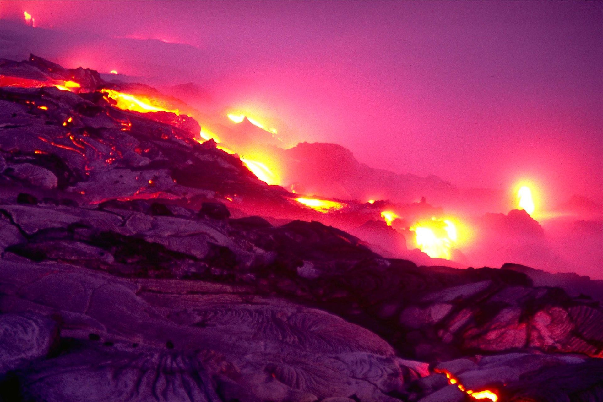 A volcano is erupting with purple and orange flames coming out of it