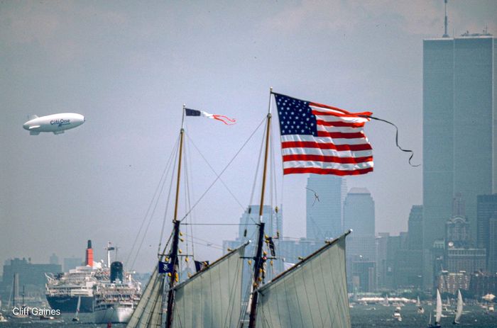 An american flag is flying in front of a city skyline