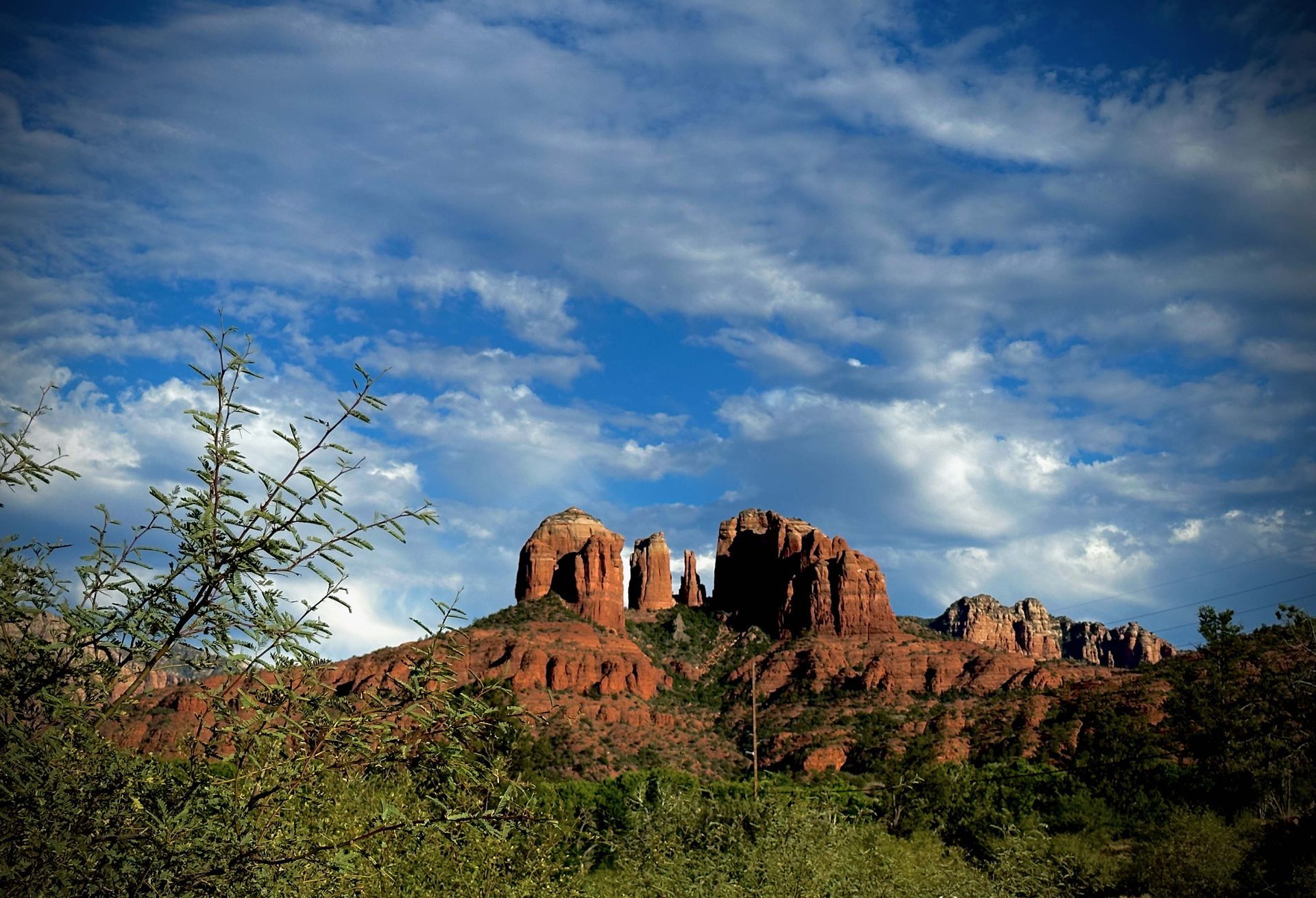 A mountain with a blue sky and clouds in the background