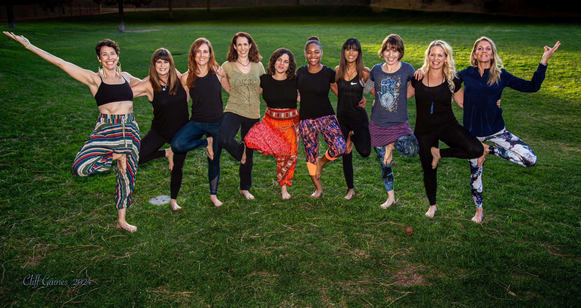 A group of women are posing for a picture in a park.