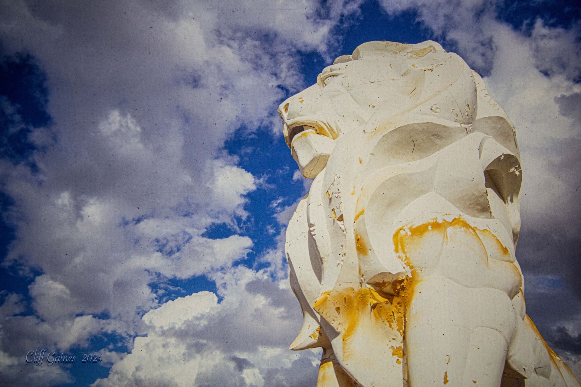 A close up of a statue with a blue sky in the background.