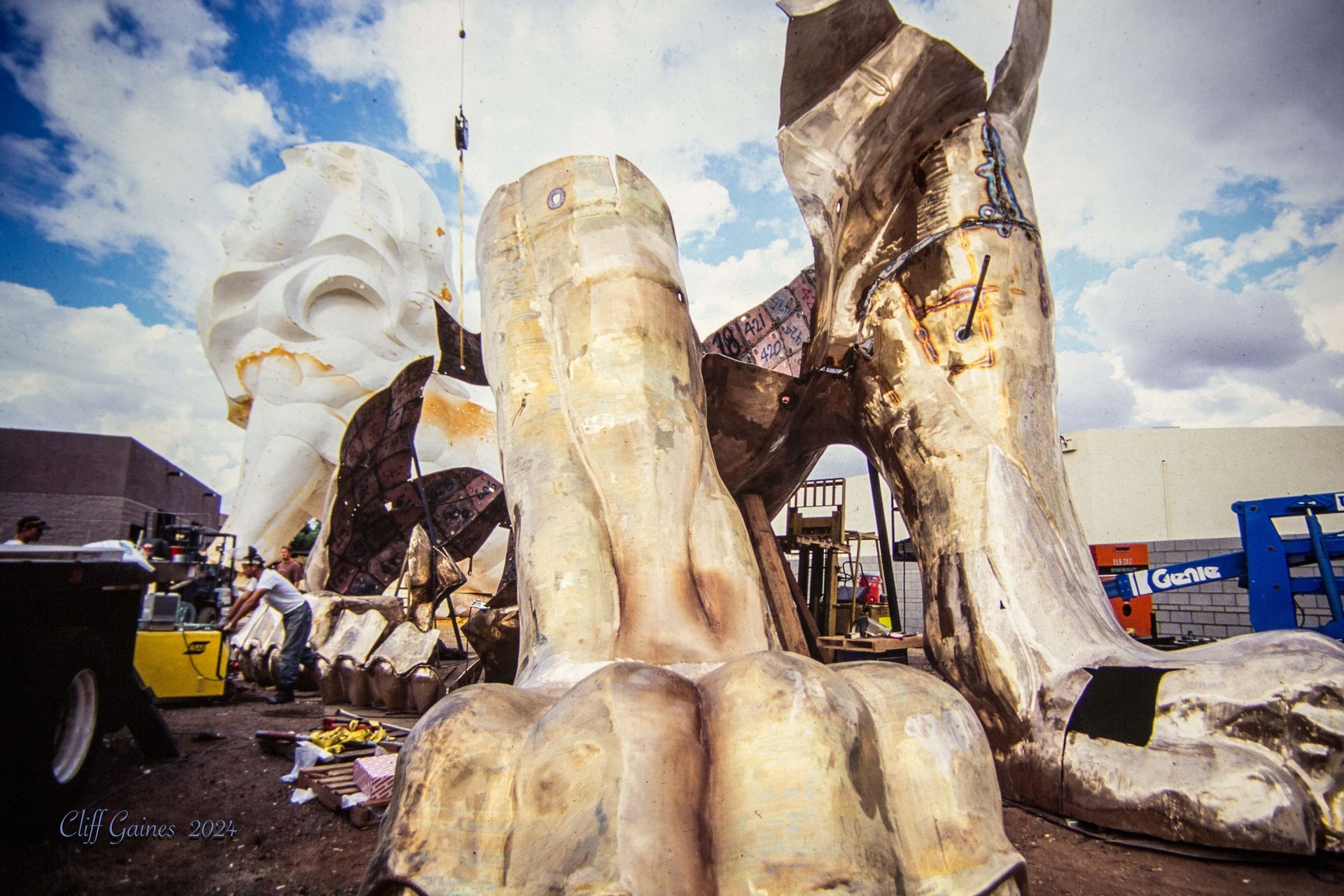 A large statue of a hand is sitting on the ground in front of a building.