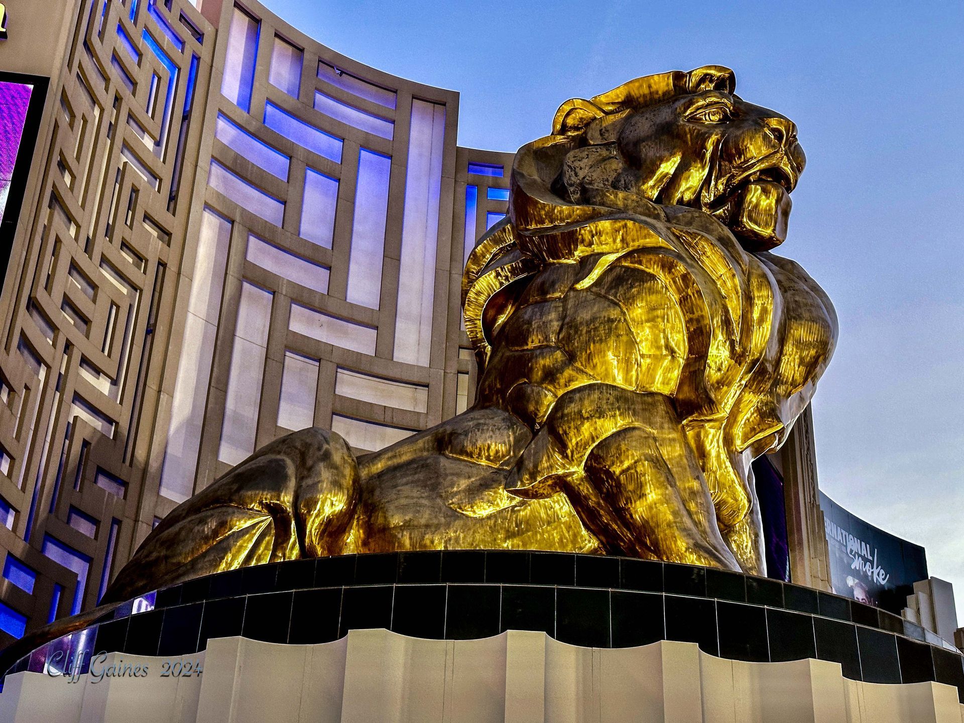 A large gold statue of a lion in front of a building