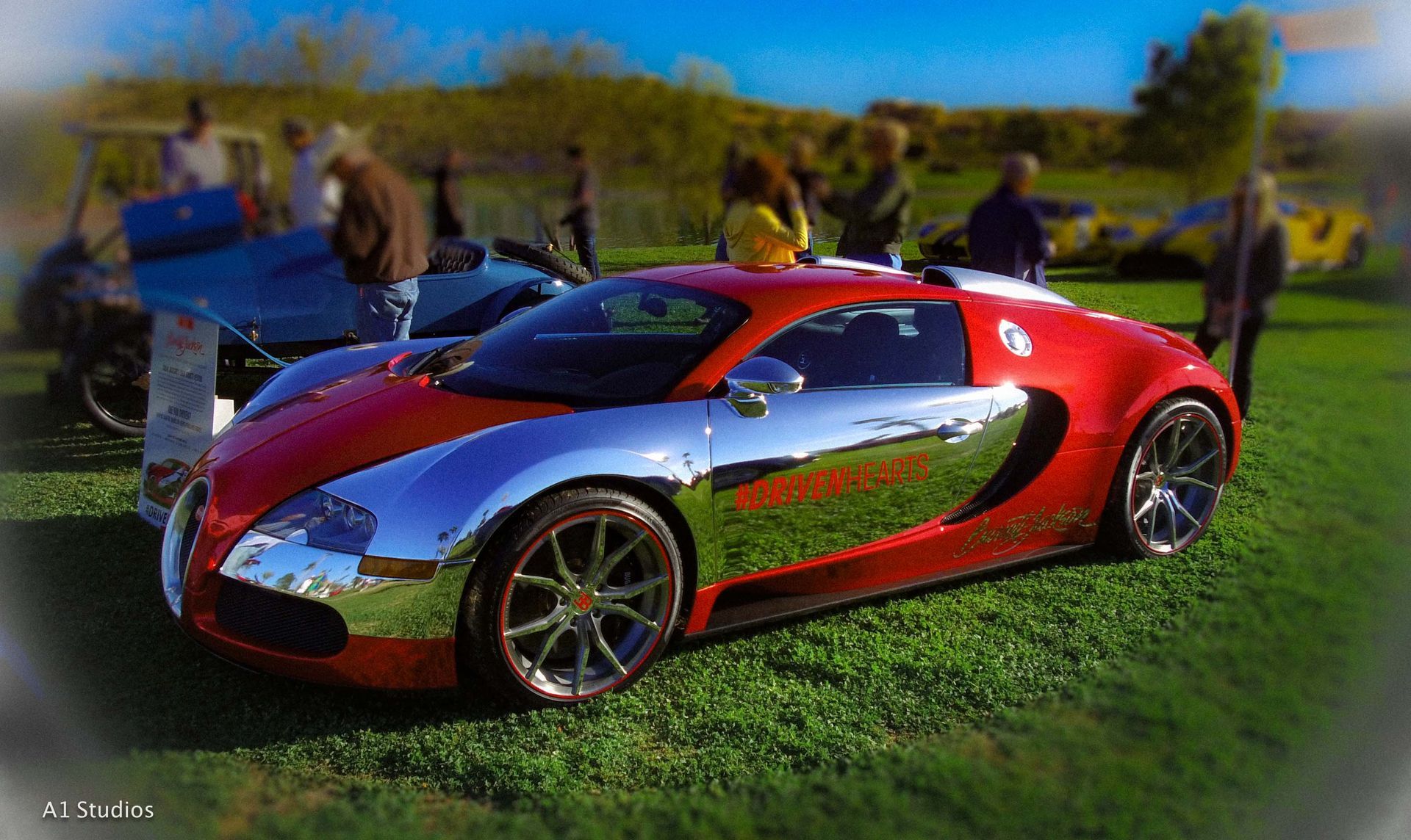 A red and silver sports car is parked in the grass