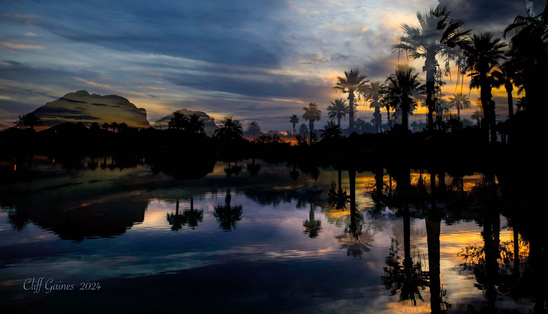A sunset over a lake with palm trees reflected in the water.