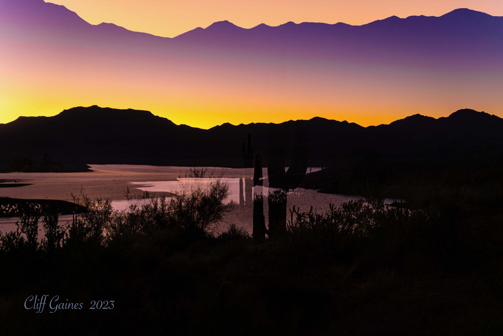 A sunset over a body of water with mountains in the background