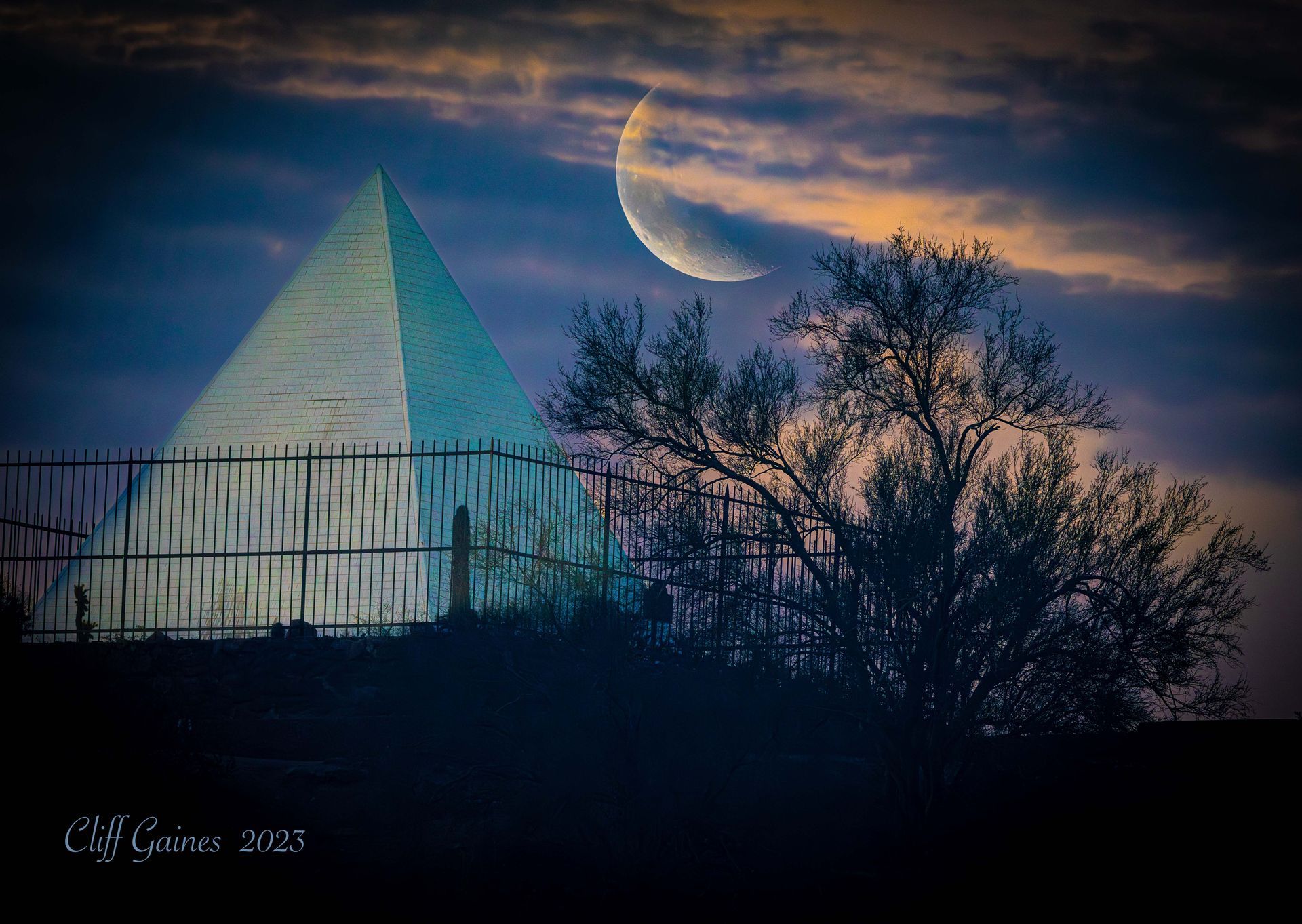 A pyramid with a crescent moon in the background