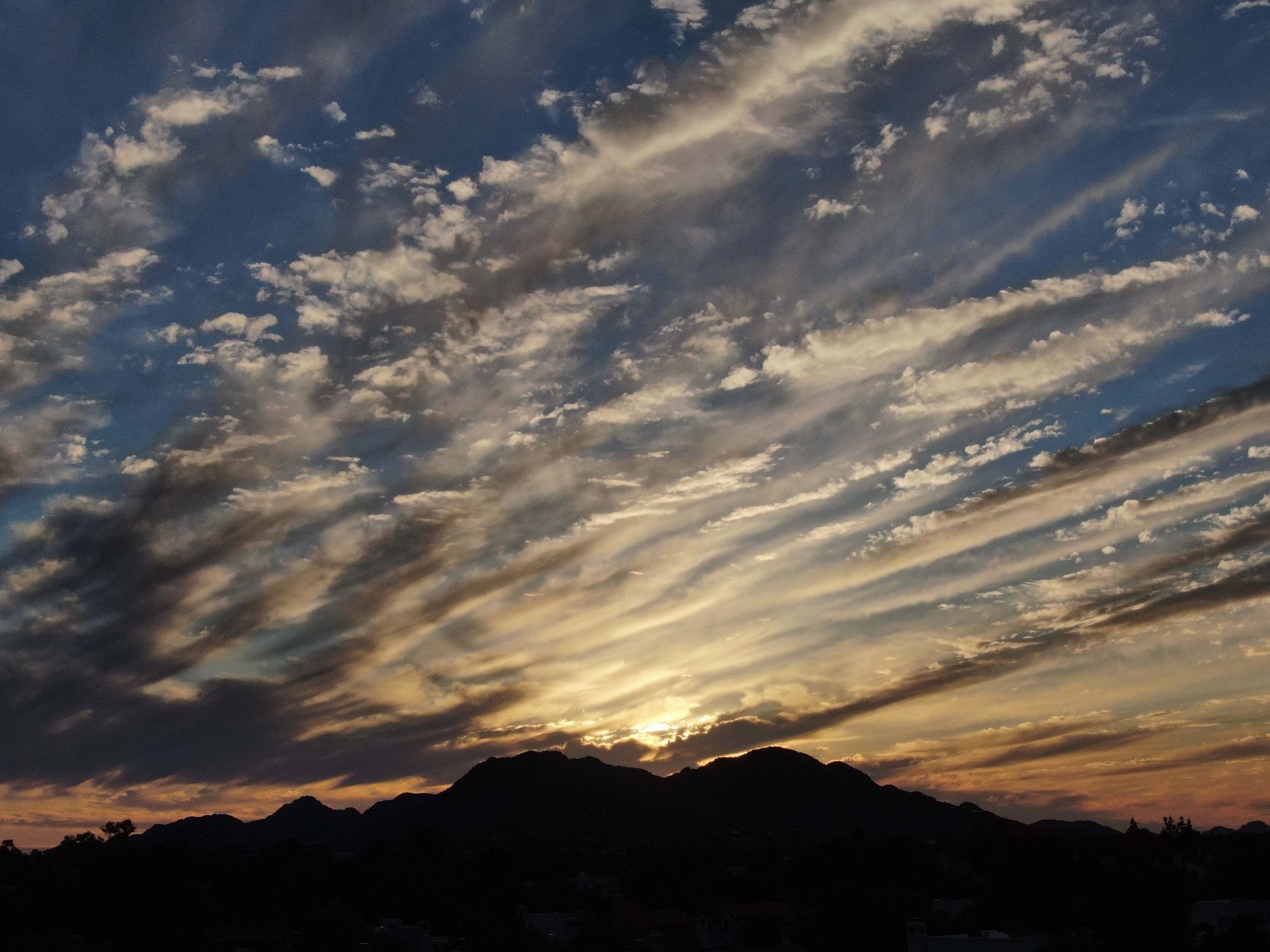 The sun is shining through the clouds over the mountains