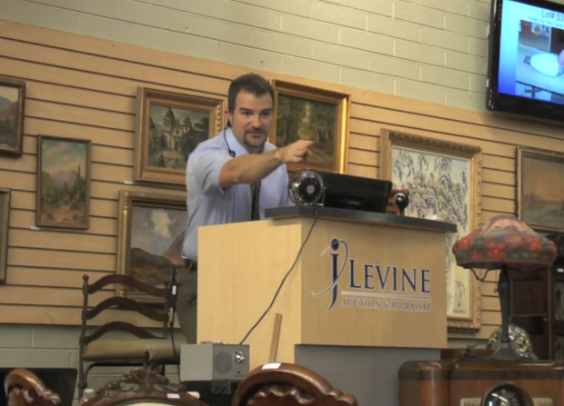 A man stands behind a podium that says levine