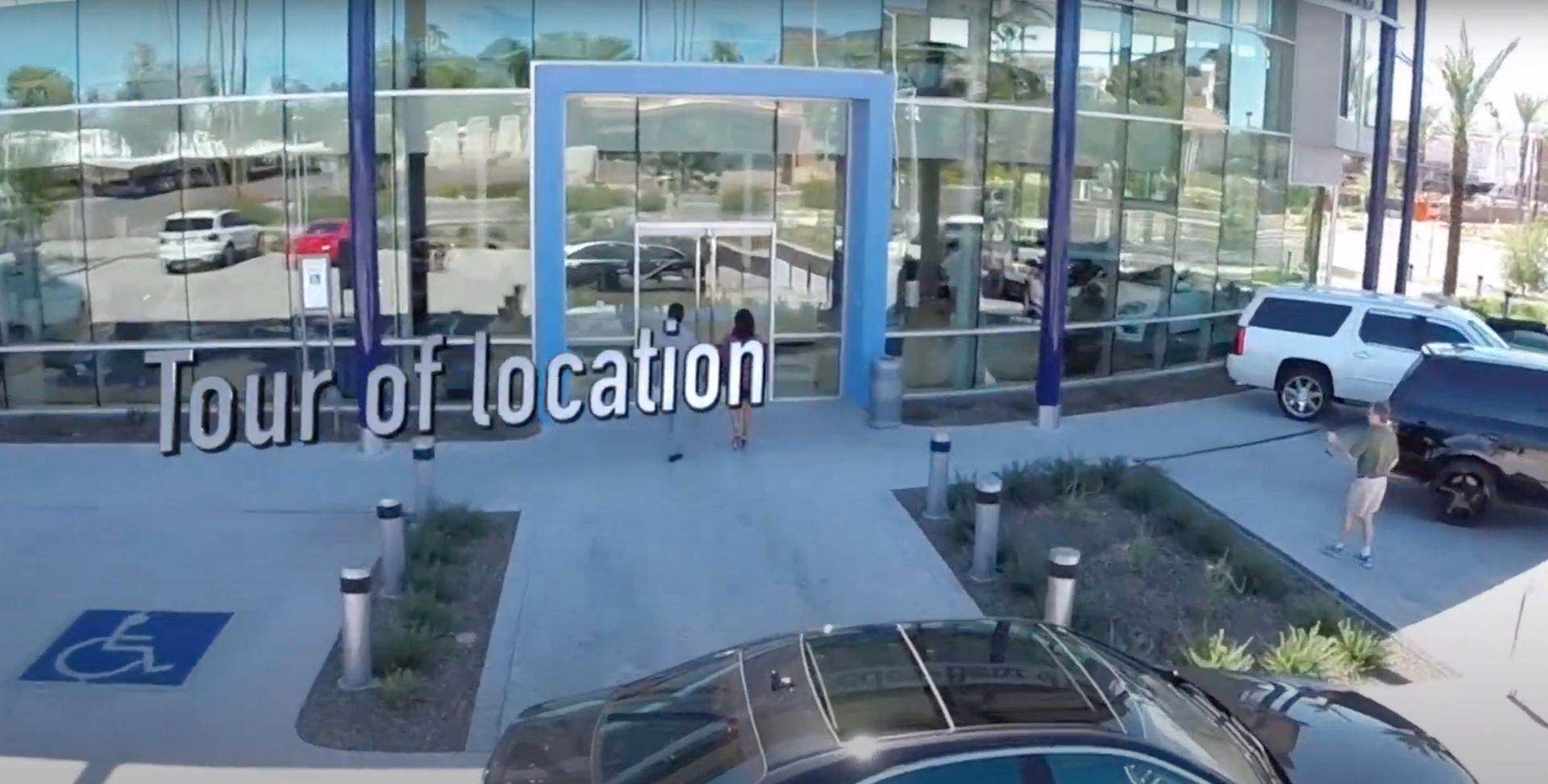 A car is parked in front of a car dealership.