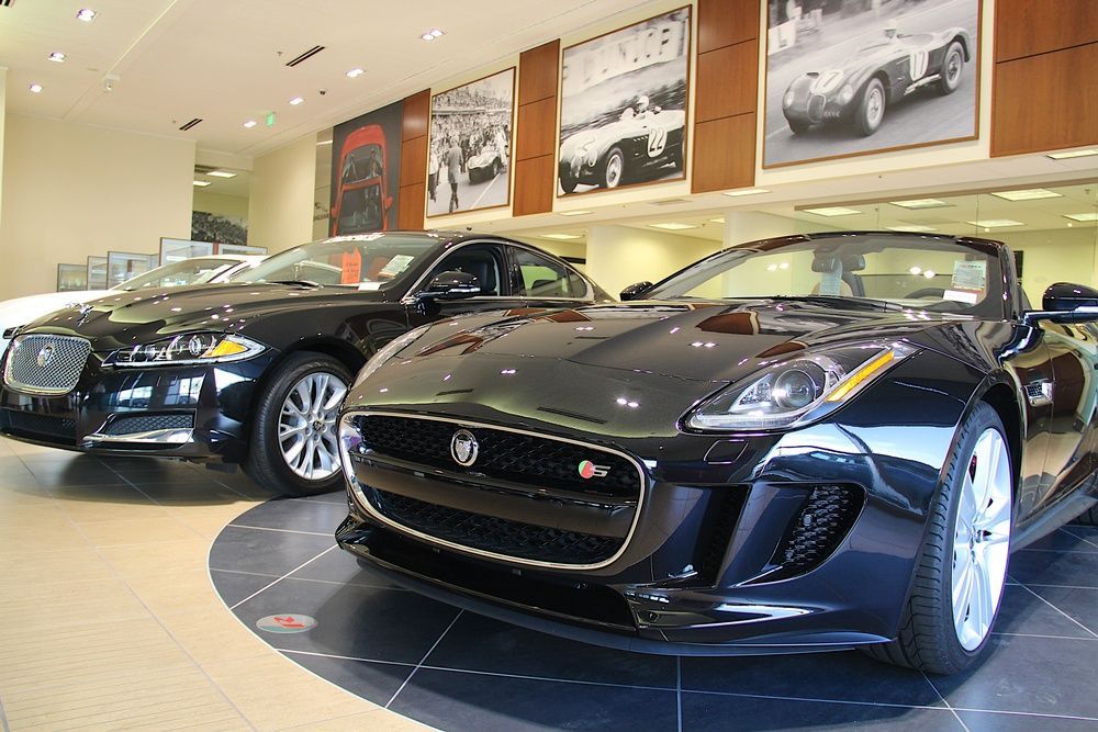 Two black sports cars are parked in a showroom.