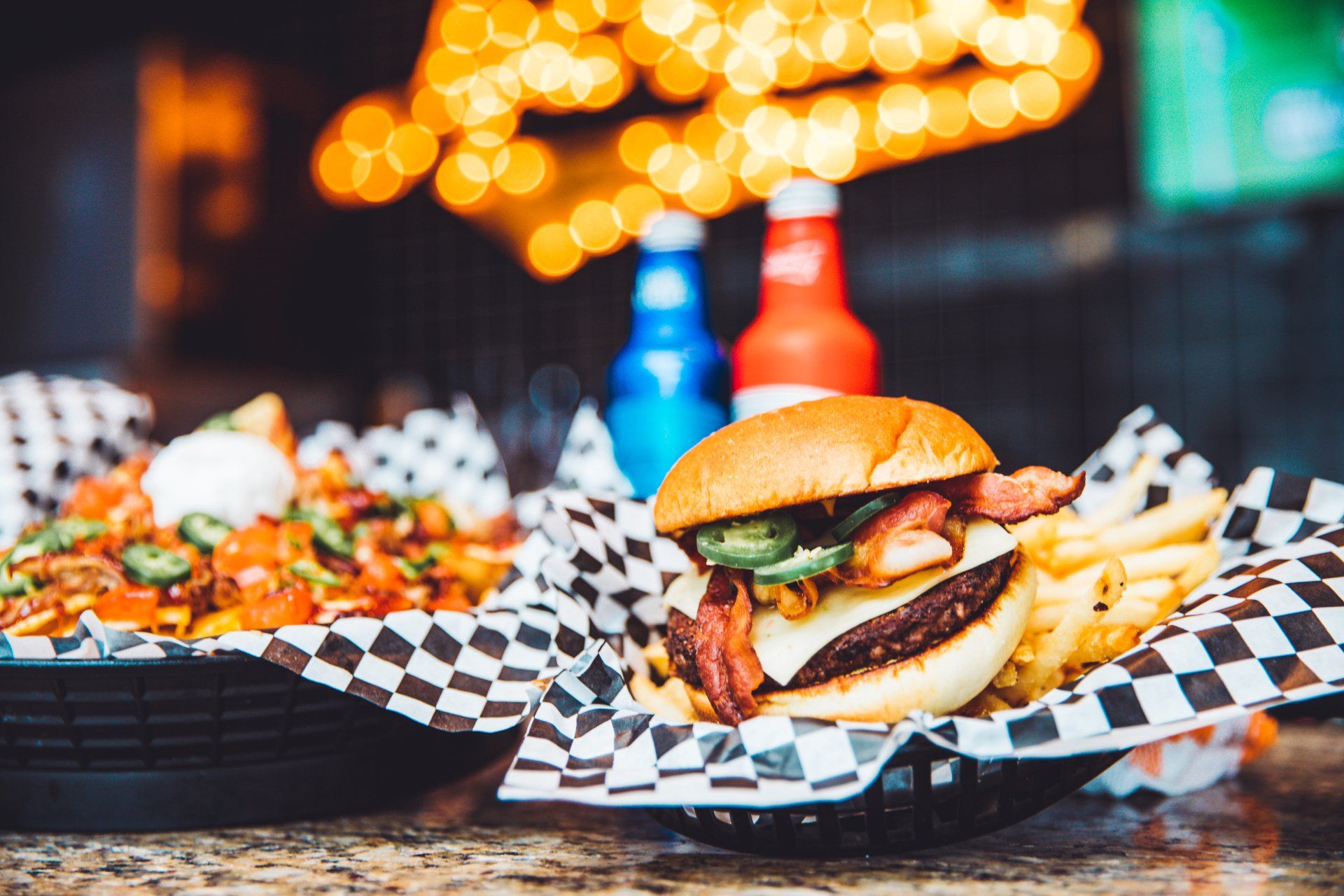 A hamburger and french fries in a basket on a table.