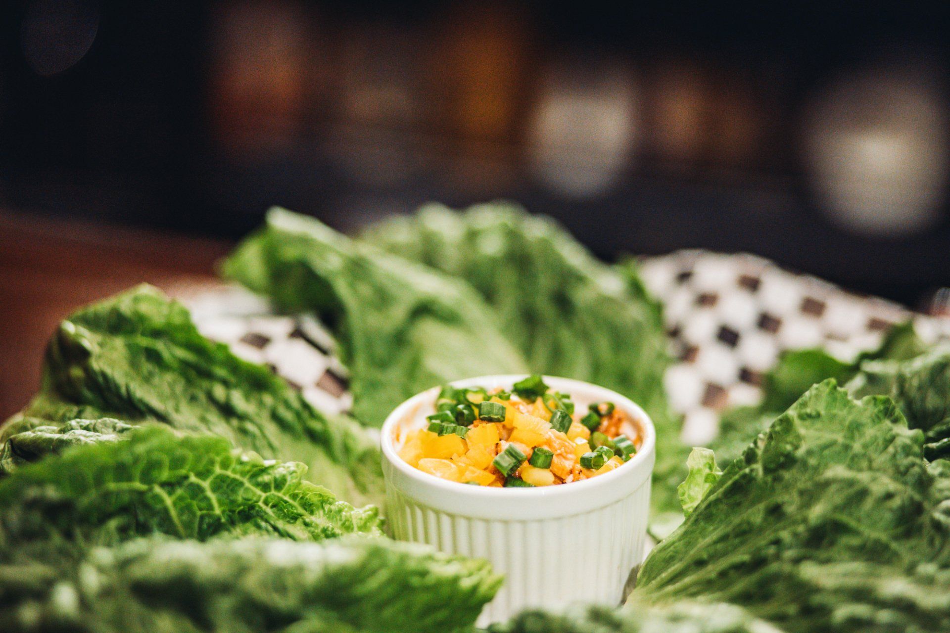 A bowl of food is sitting on top of lettuce leaves.