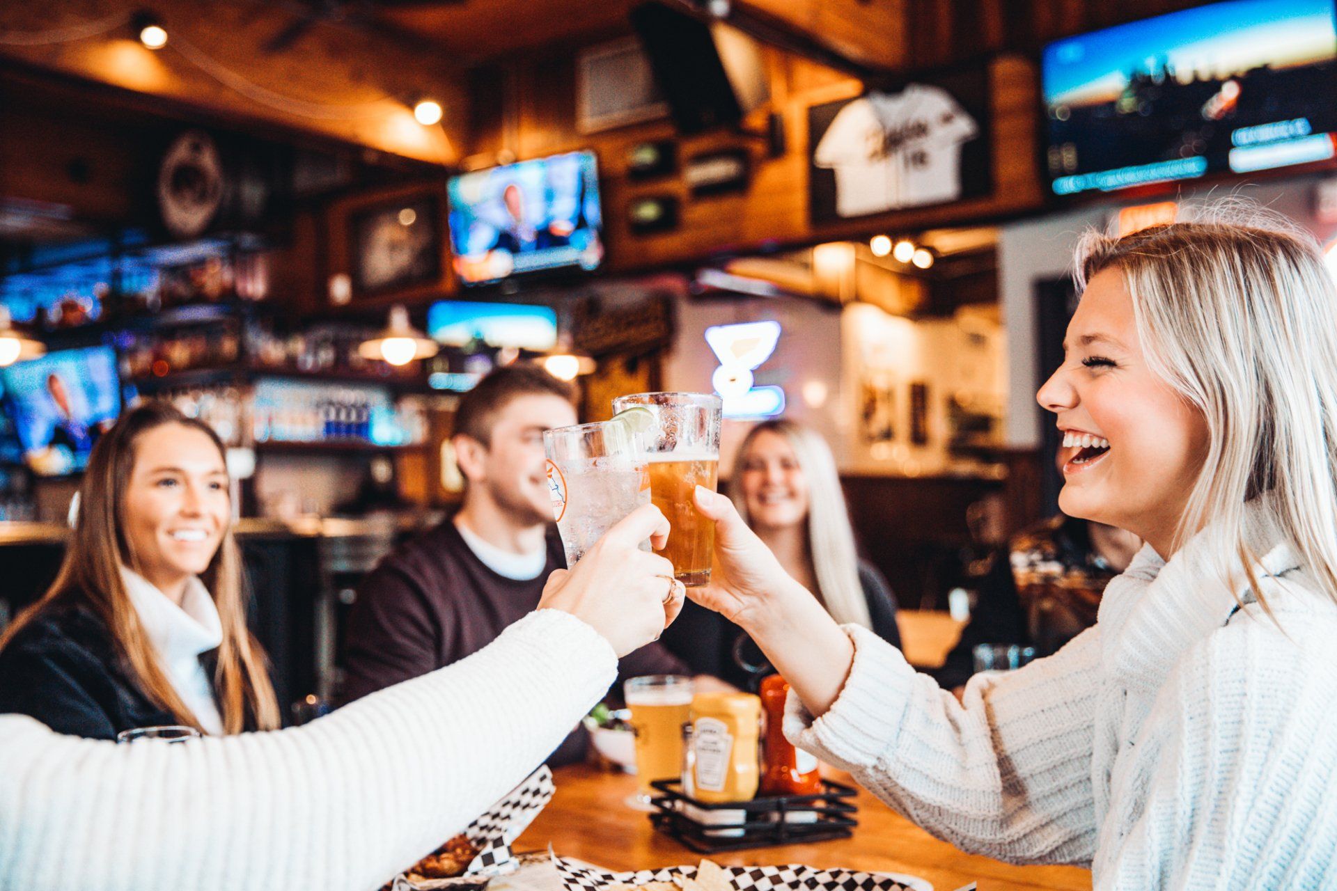 A group of people are toasting with beer in a restaurant.
