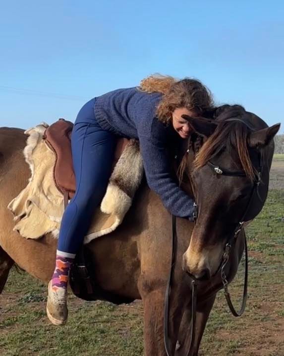 photo of Maggie hugging her horse buzz