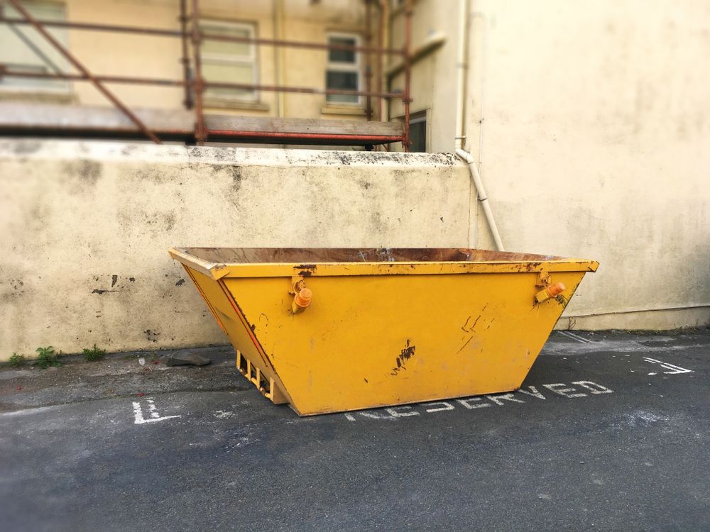 Yellow Skip Bin Parked in A Reserved Space Against a Weathered Building — UBIN in Ballina, NSW