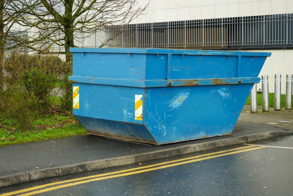 Blue Dumpster on A Sidewalk Next to A Road, in Front of A Building — UBIN in Kyogle, NSW