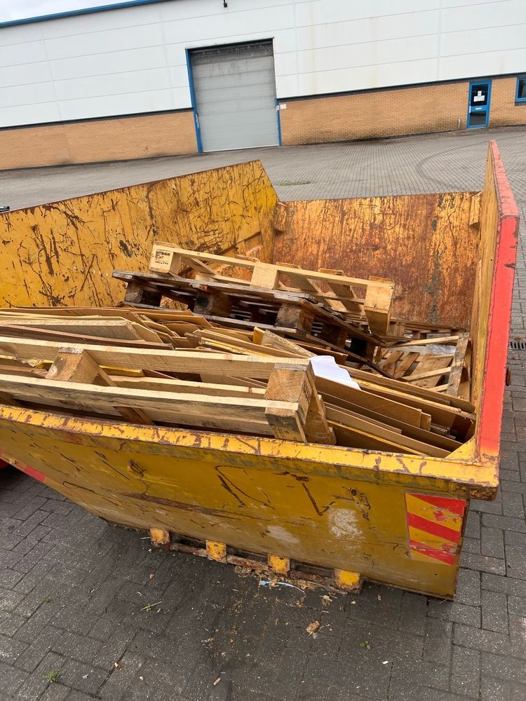 Yellow Industrial Dumpster Filled with Discarded Wooden Pallets Outdoors — UBIN in Byron Bay, NSW