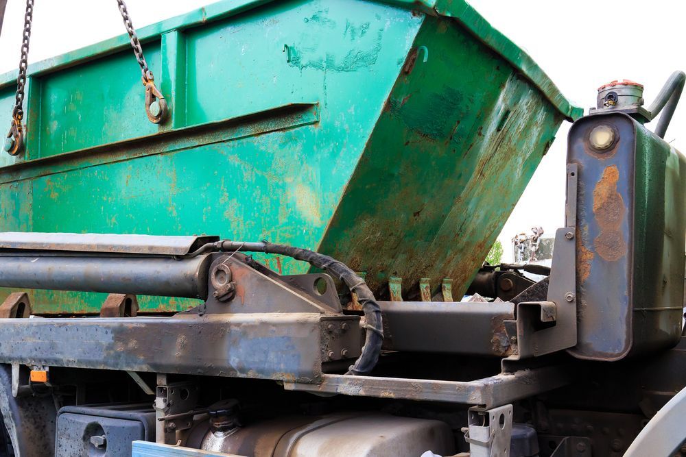 Green Dumpster Being Lifted by A Truck. Rusty Metal and Hydraulic System Visible — UBIN in Ocean Shores, NSW