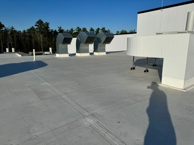 A shadow of a person is cast on the roof of a building
