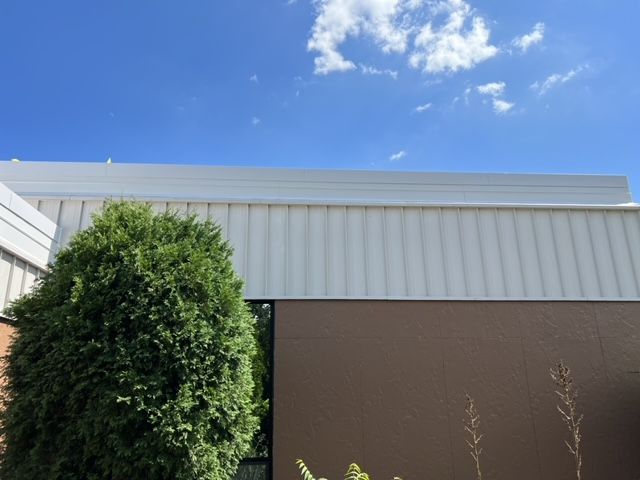 A building with a tree in front of it and a blue sky
