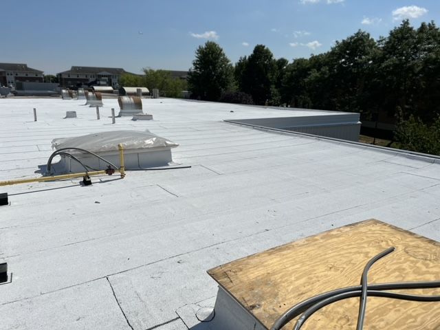 A white roof with a skylight on top of it