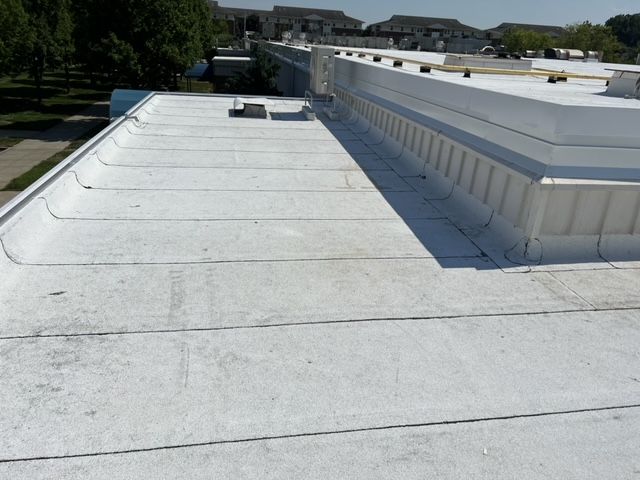 A white roof of a building with trees in the background