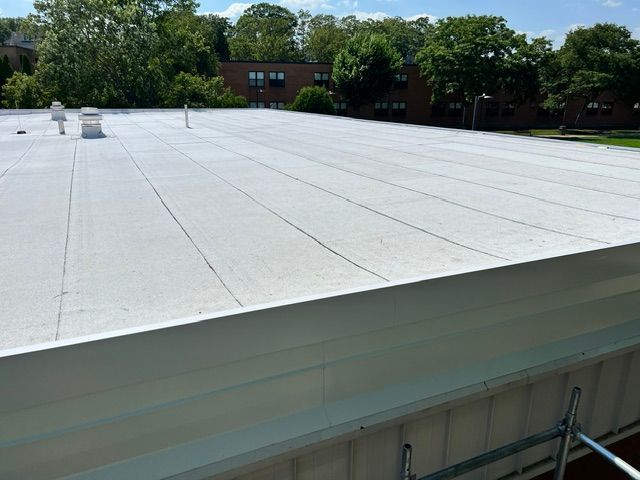 A white roof of a building with trees in the background