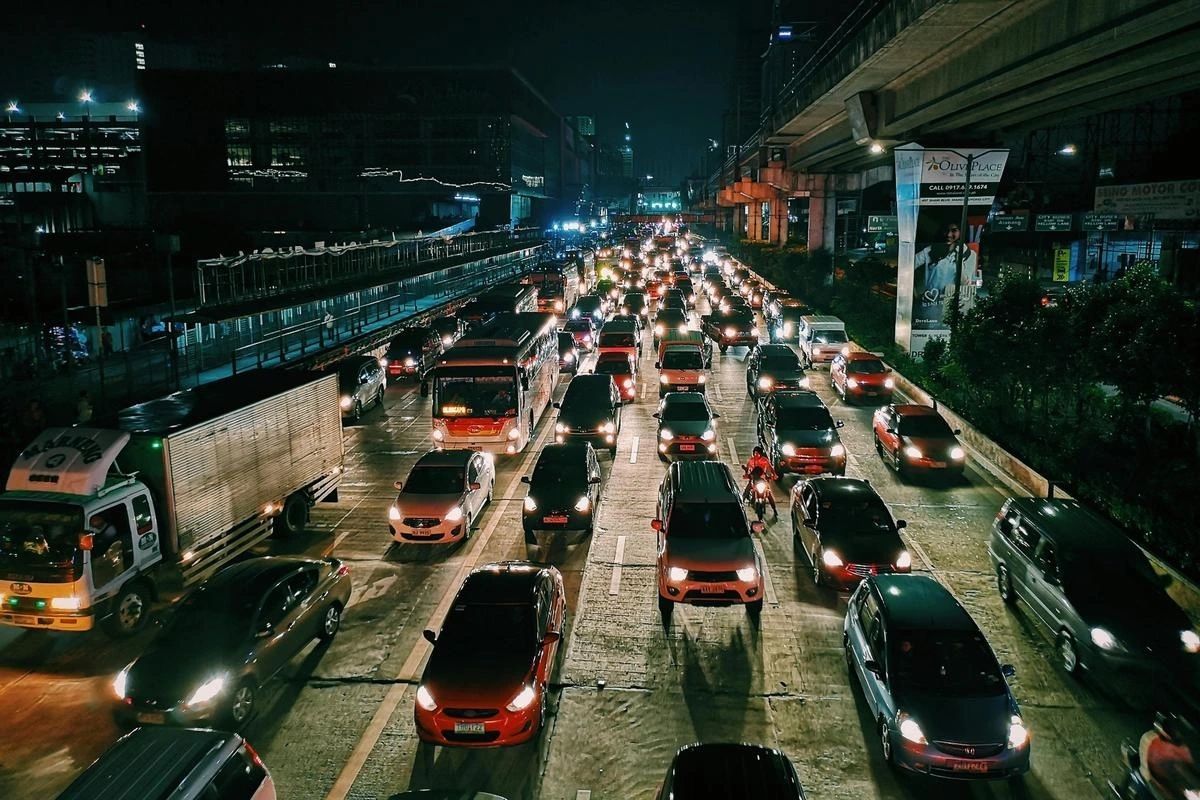 Nighttime highway packed with heavy traffic, cars and buses bumper-to-bumper with headlights glowing