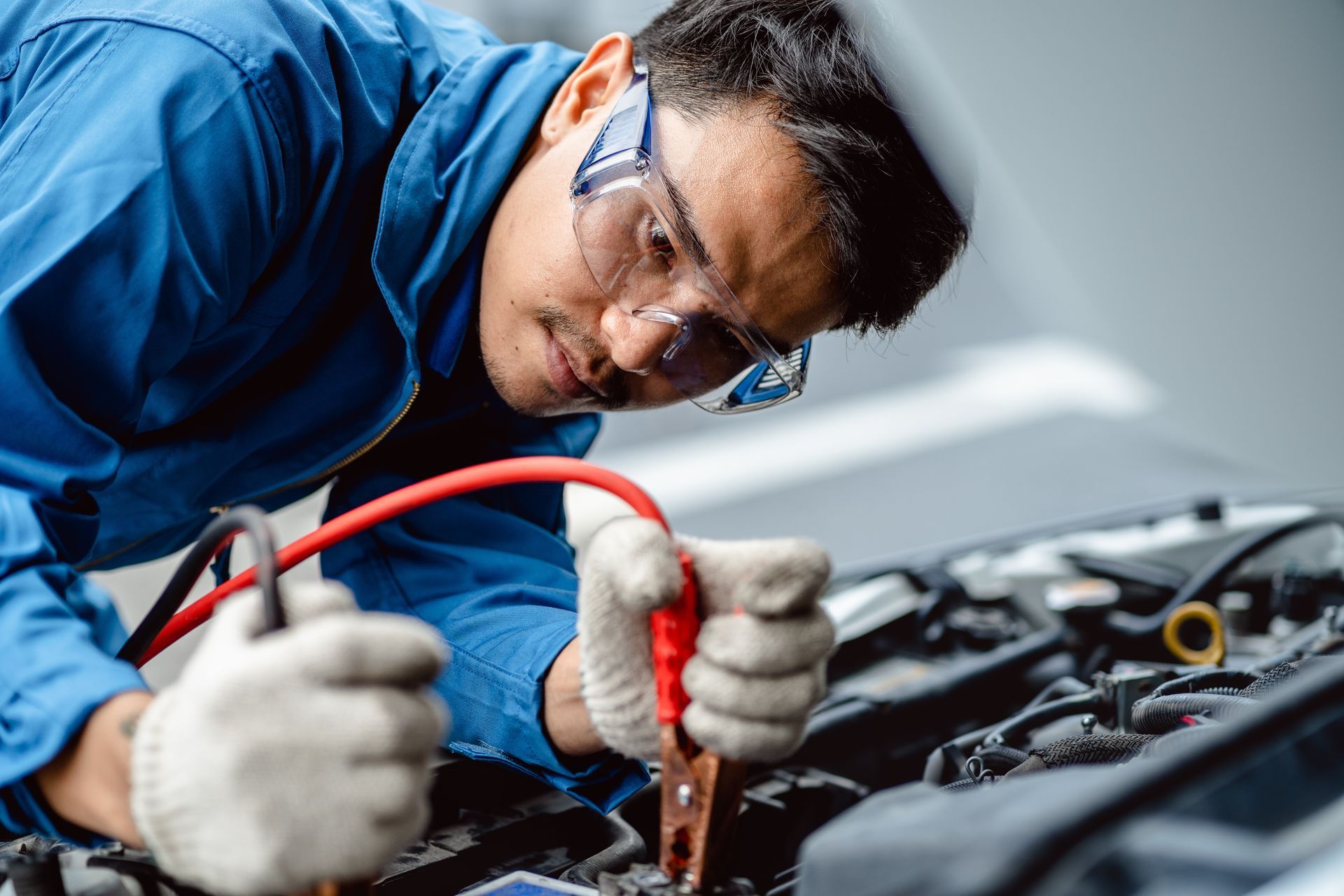 A man is working on the engine of a car.