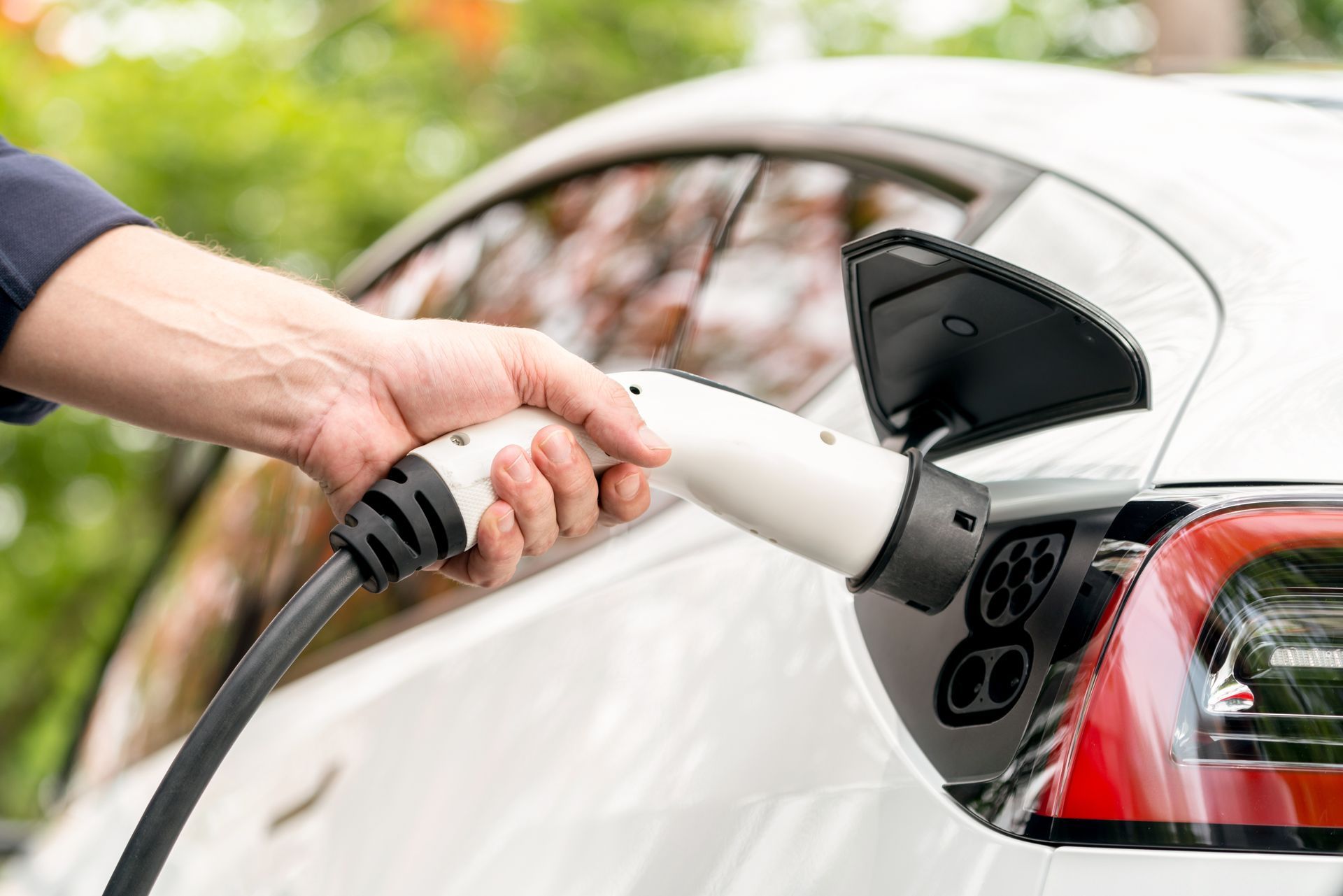 A person is charging an electric car with a charger.