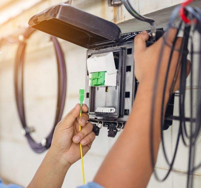 An Internet Technician Is Repairing A Fiber Optic Connection — 7E Integrated Services In Maitland NSW