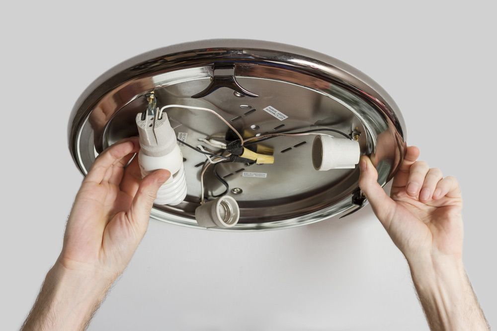 Hands Electrician Replace And Screwed The Bulb — 7E Integrated Services In Maitland NSW