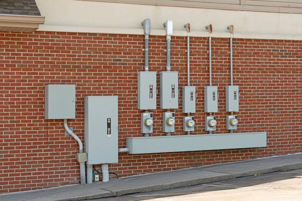 Electric Meters For A Commercial Strip Center Mounted On A Red Brick Wall — 7E Integrated Services In Maitland NSW