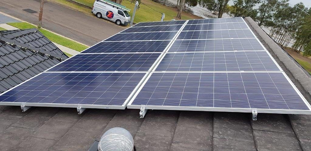 Twelve solar panels newly installed on a roof.