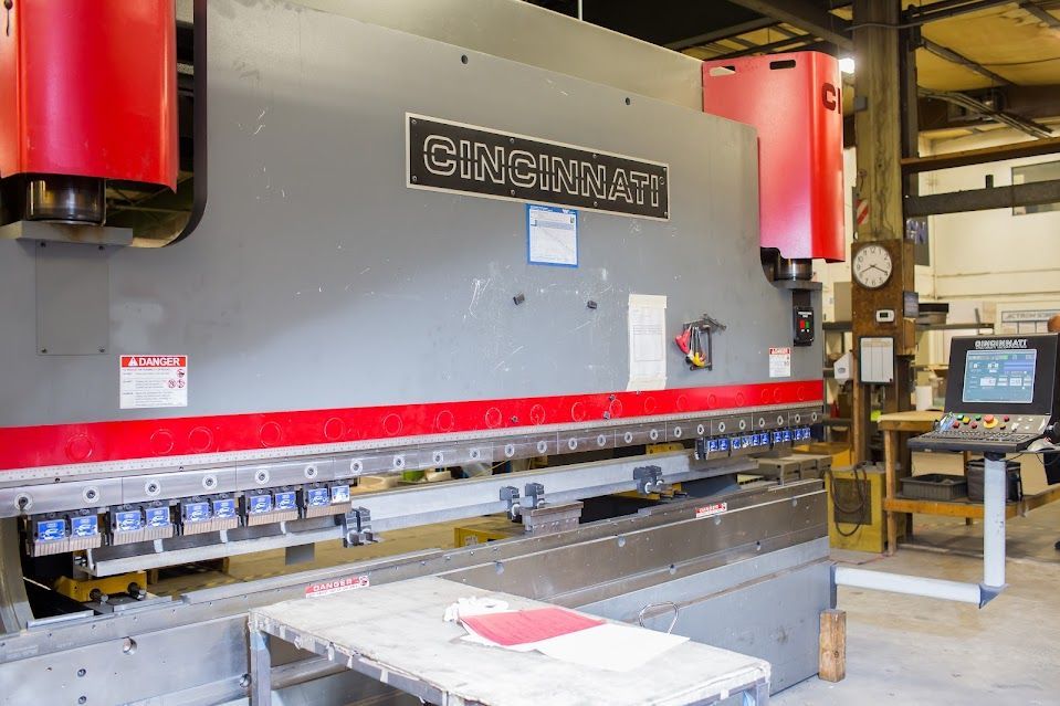 Large gray and red Cincinnati press brake machine in a workshop.