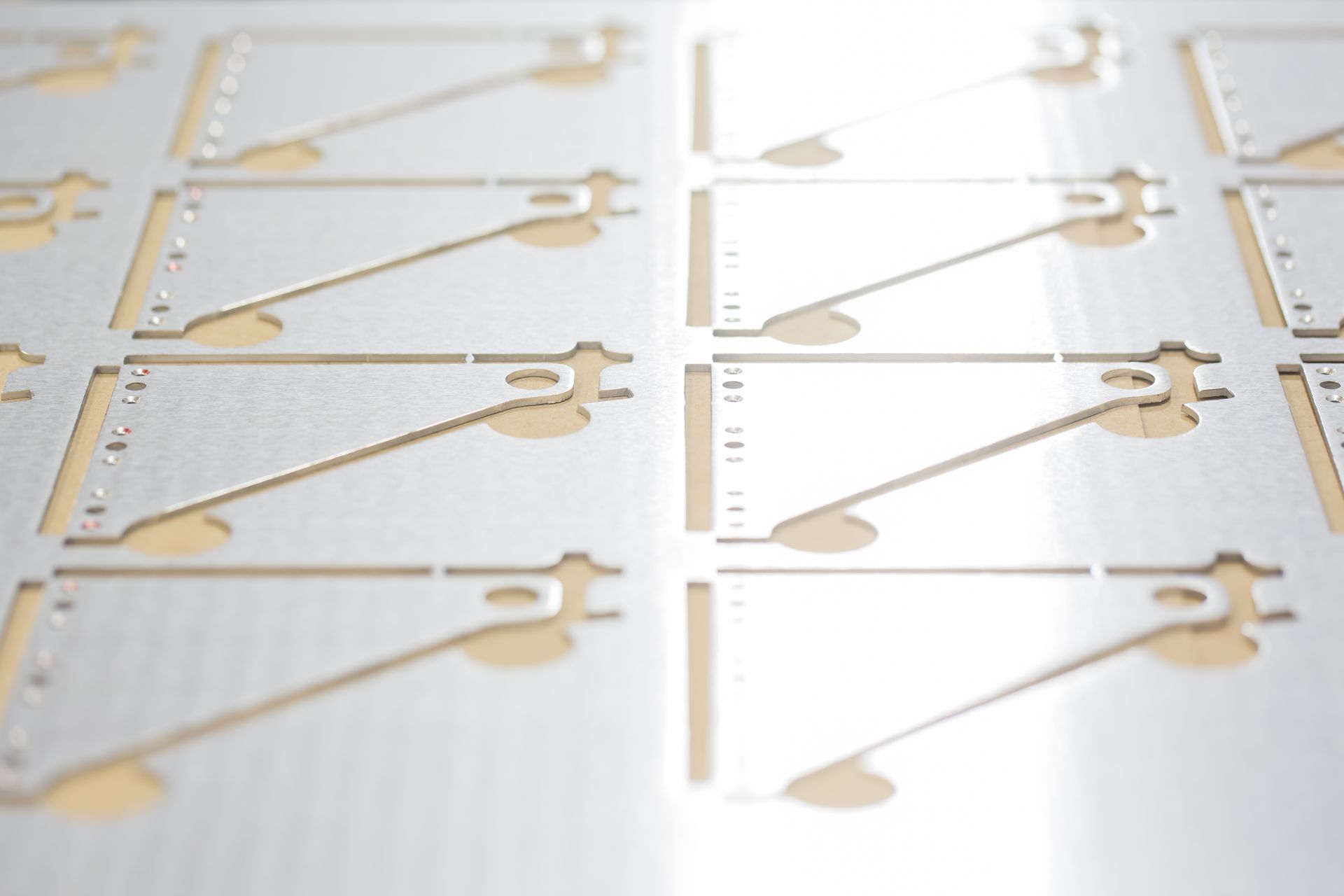 A metal sheet with a repeating pattern of cut-out shapes, possibly stencils.