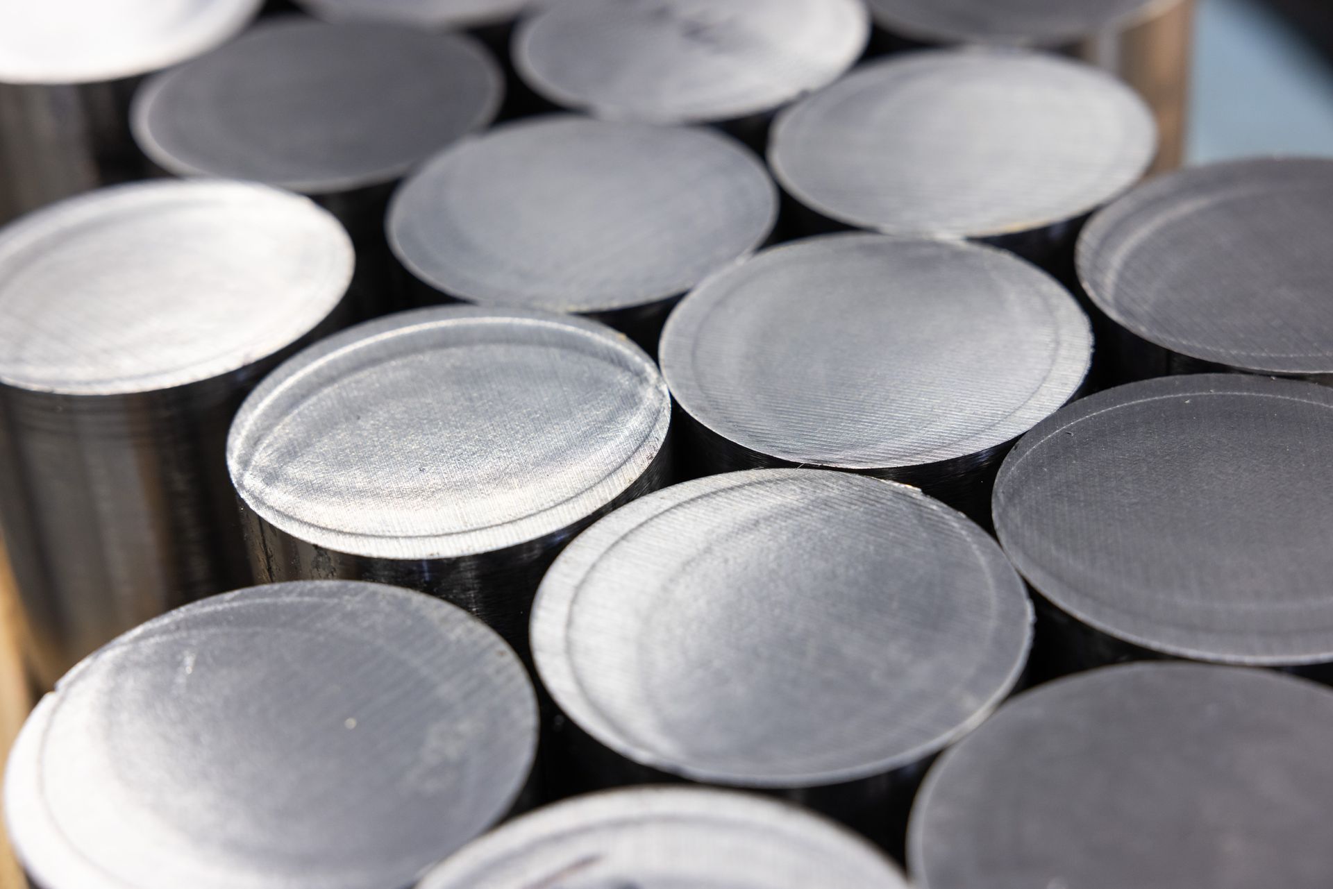 Close-up of numerous, round, flat, silver-colored metal pieces stacked together.