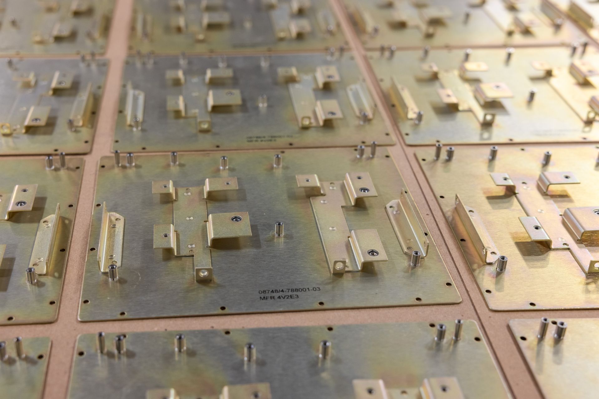 Arrangement of brass circuit boards, some with raised metal components.