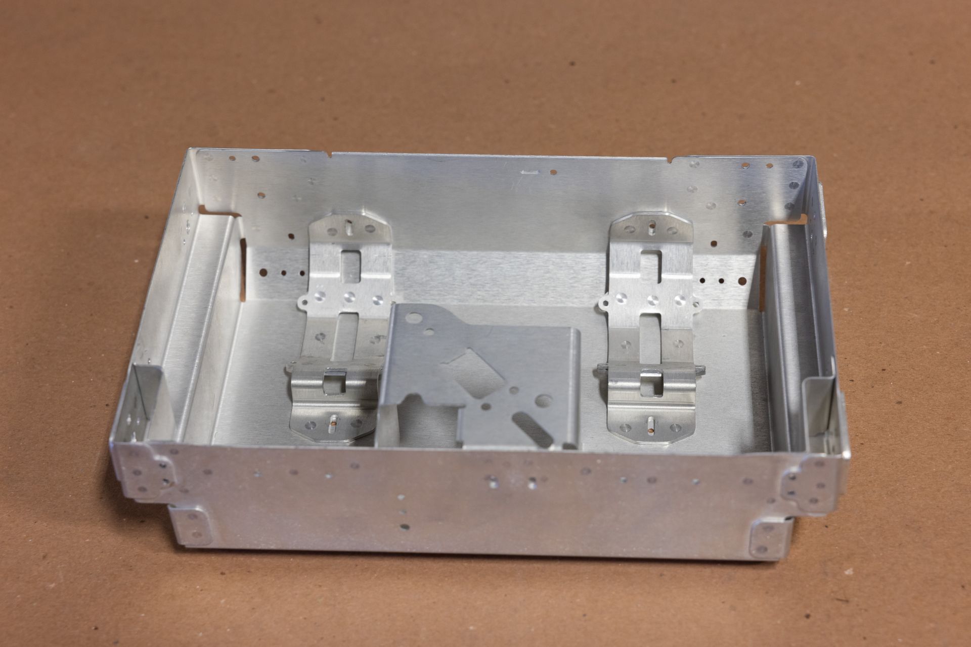 Aluminum box with attached hinges and brackets, possibly for an electronic component.