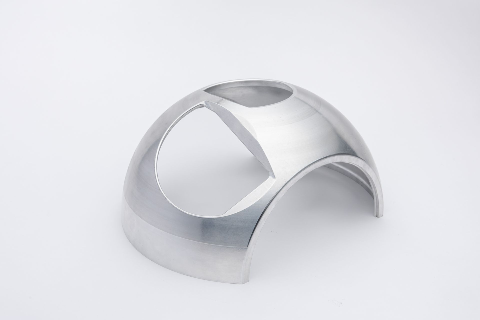 Silver metal domed structure with curved cutouts, set against a white background.