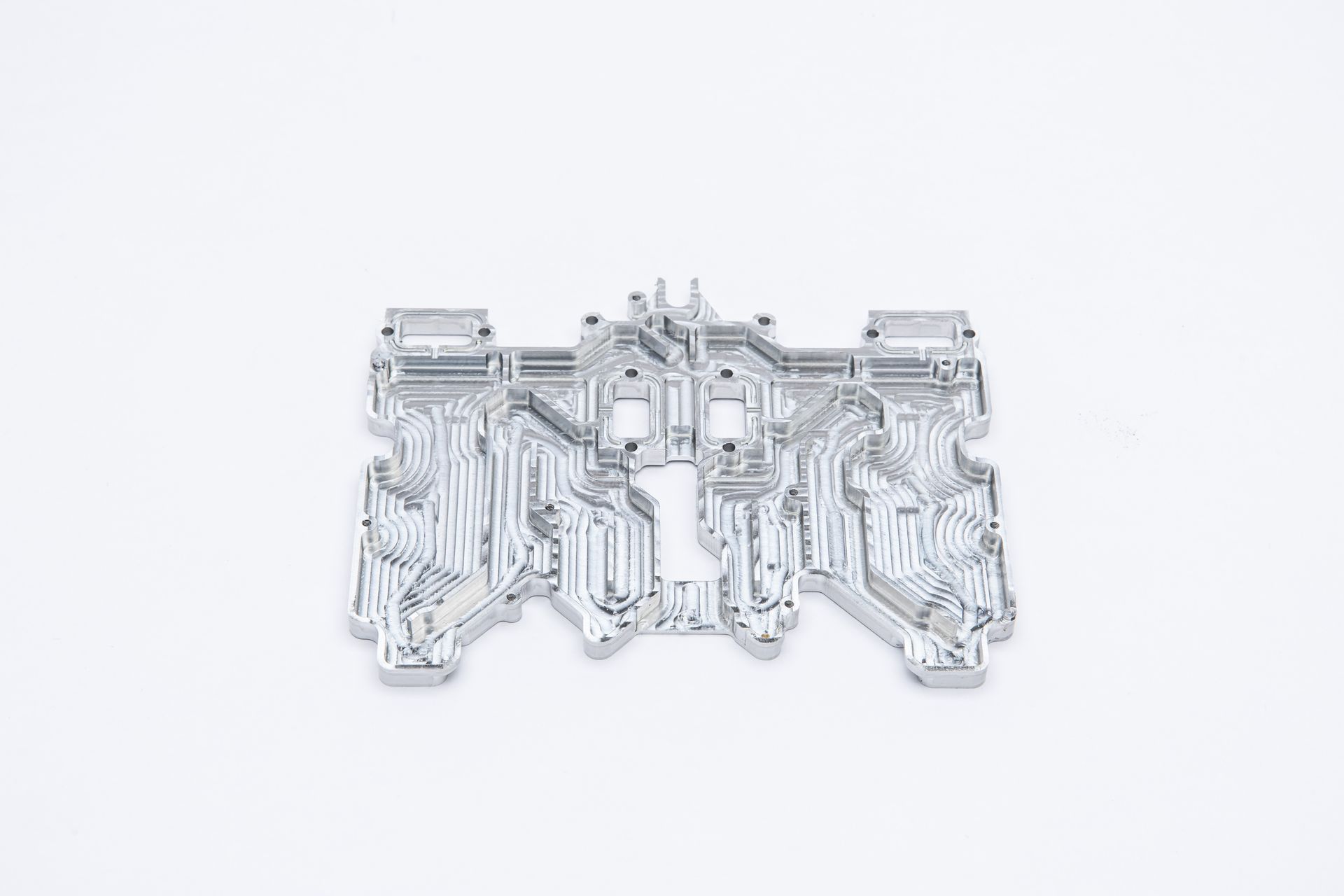 Silver circuit board-like component on a white background.