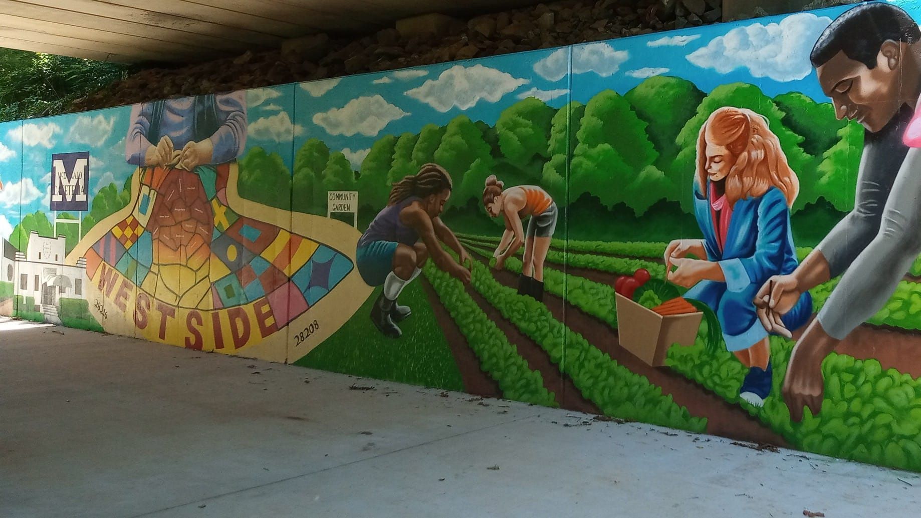 Mural on a wall depicting people working in a garden, with blue sky and trees in the background. 