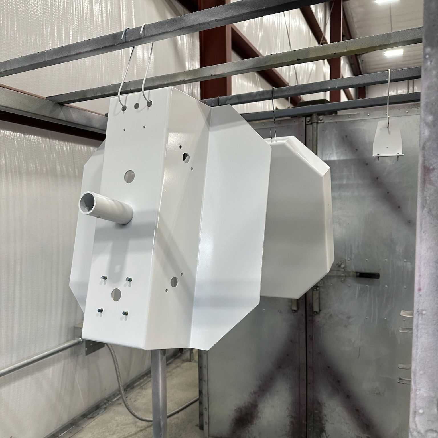 A white fabricated object is hanging from the ceiling in a room