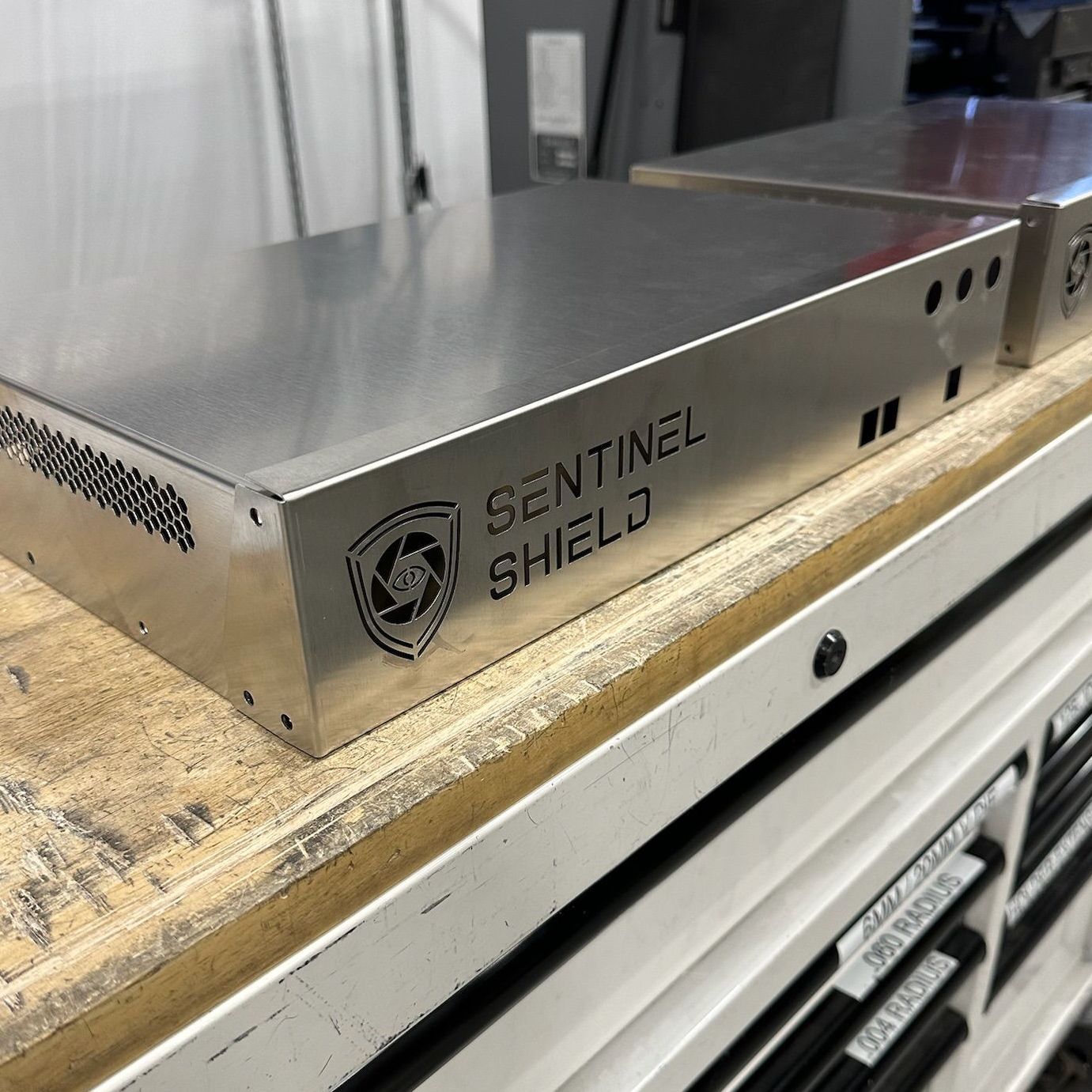 A sentinel shield device is sitting on top of a wooden table.