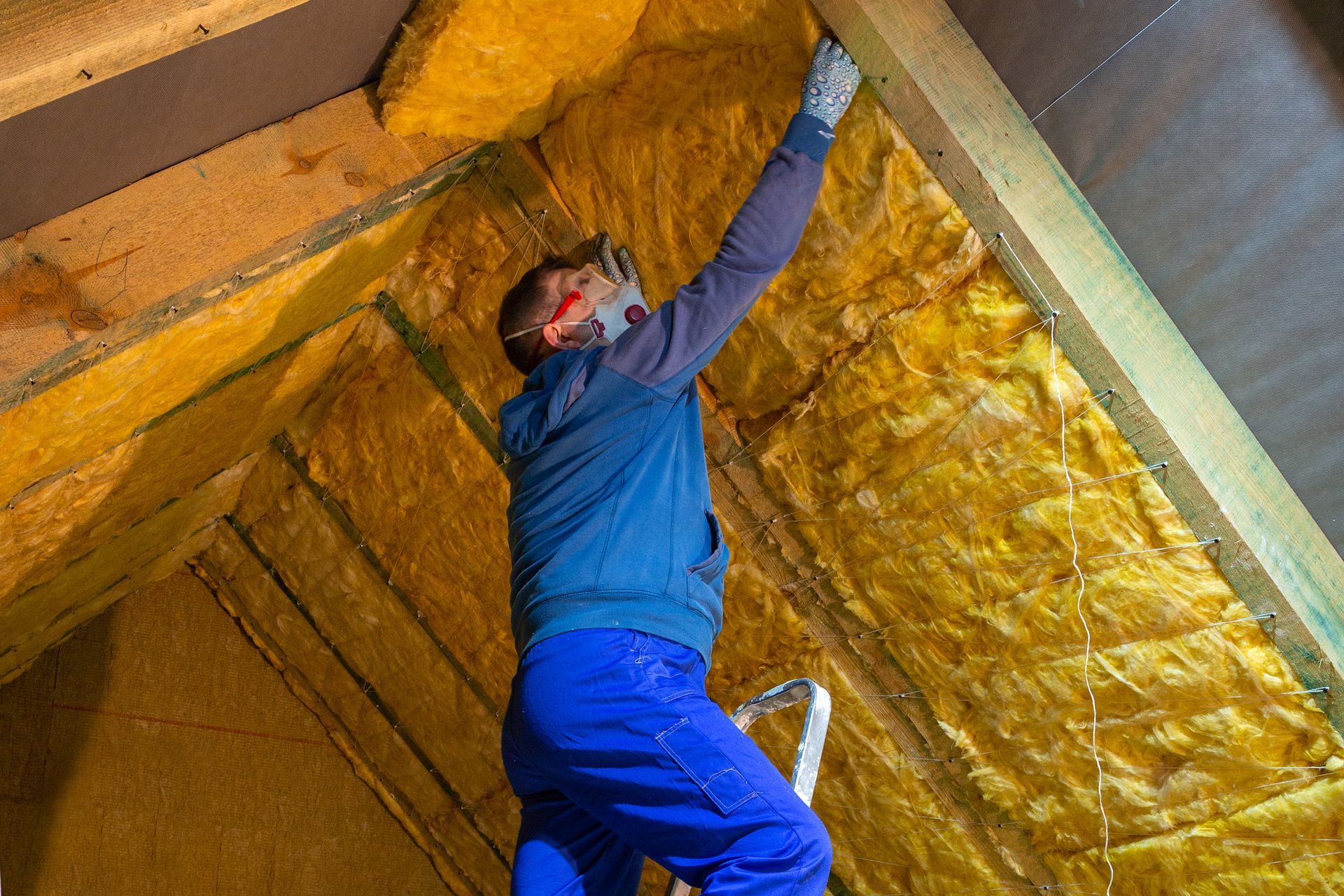 A man is insulating the attic of a house.