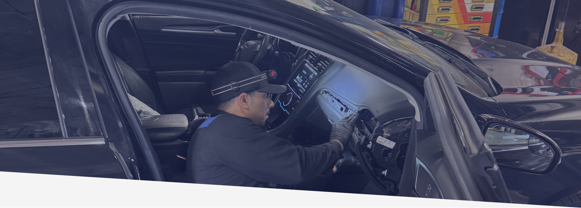 Man wearing a hat fixes inside of a car | Greg's Garage