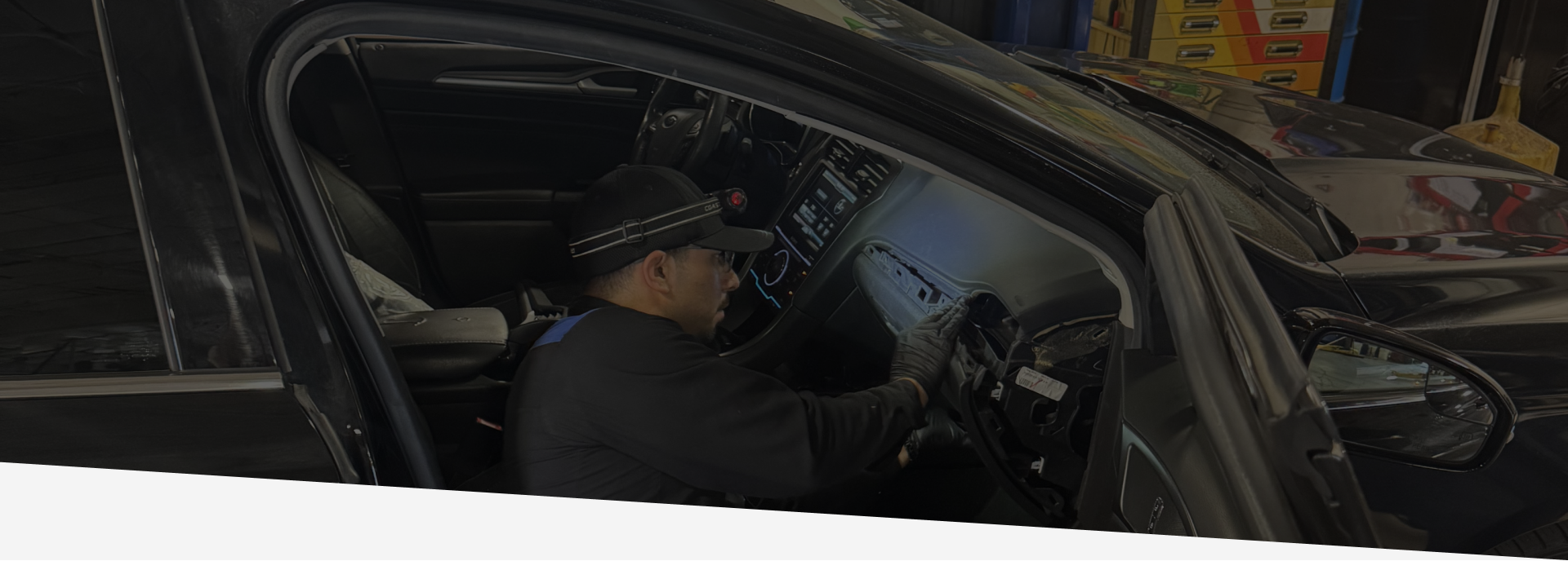 Man wearing a hat fixes inside of a car | Greg's Garage