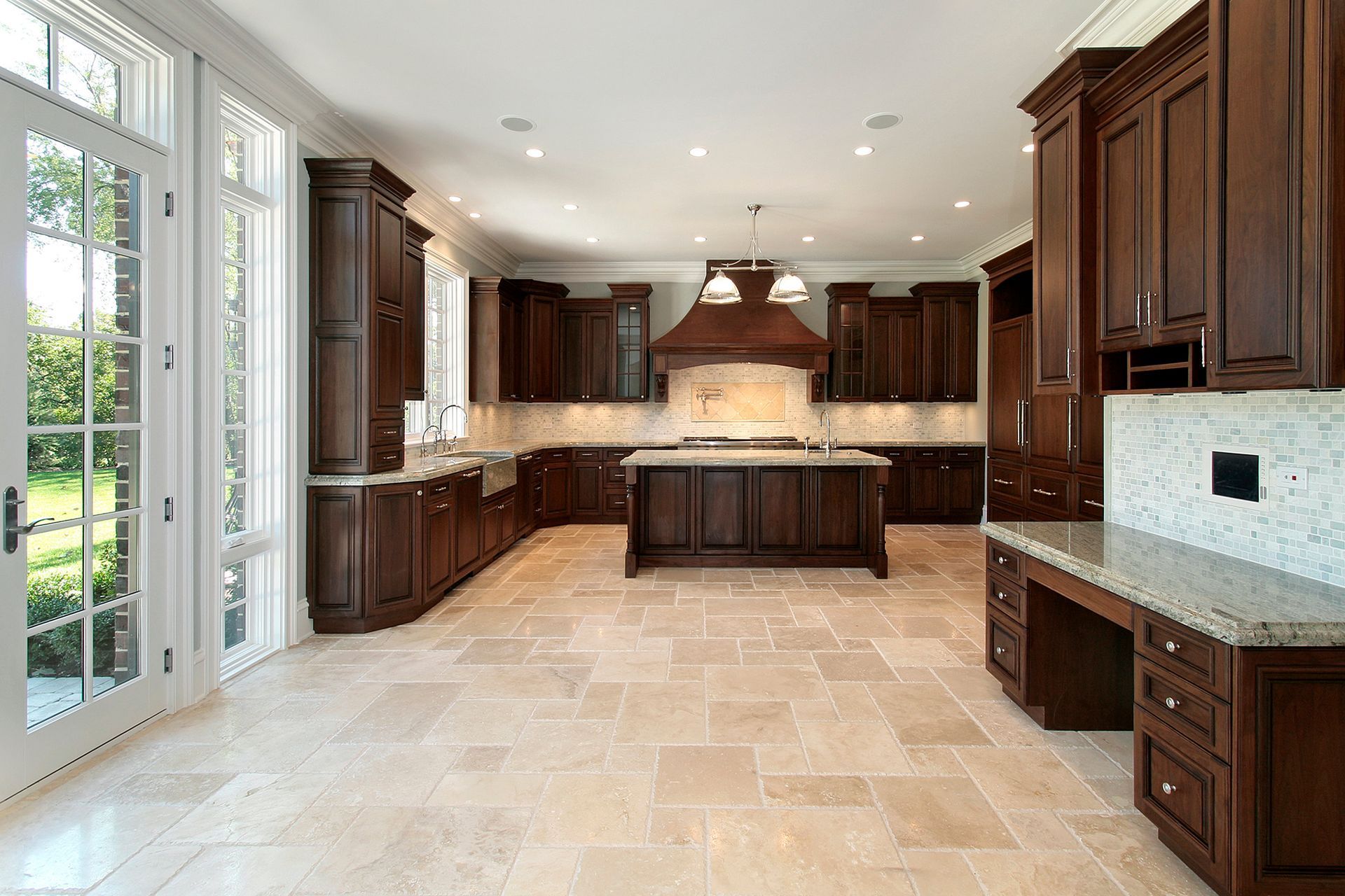 Spacious kitchen with dark wood cabinets, beige tile floor, large island, and granite countertops